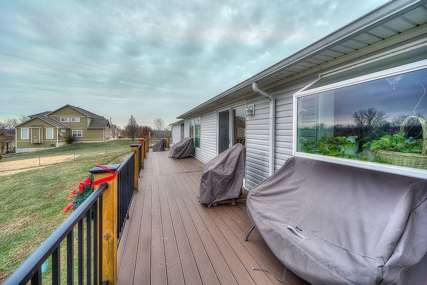 There is a large deck with a lot of furniture on it.