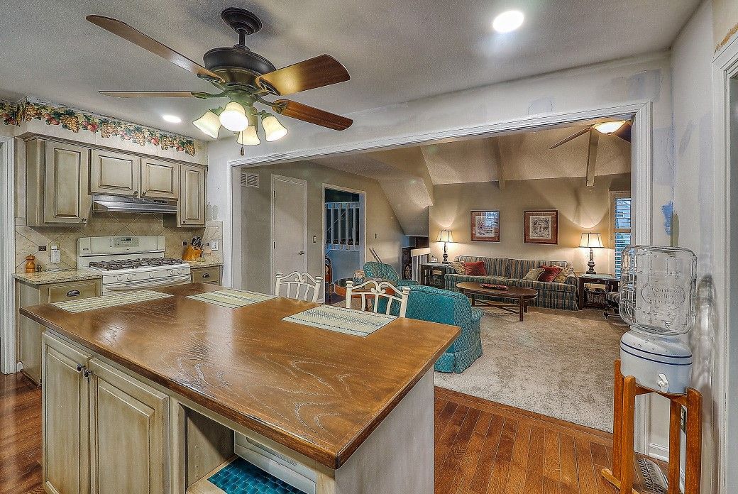 A kitchen with a large island and a ceiling fan.