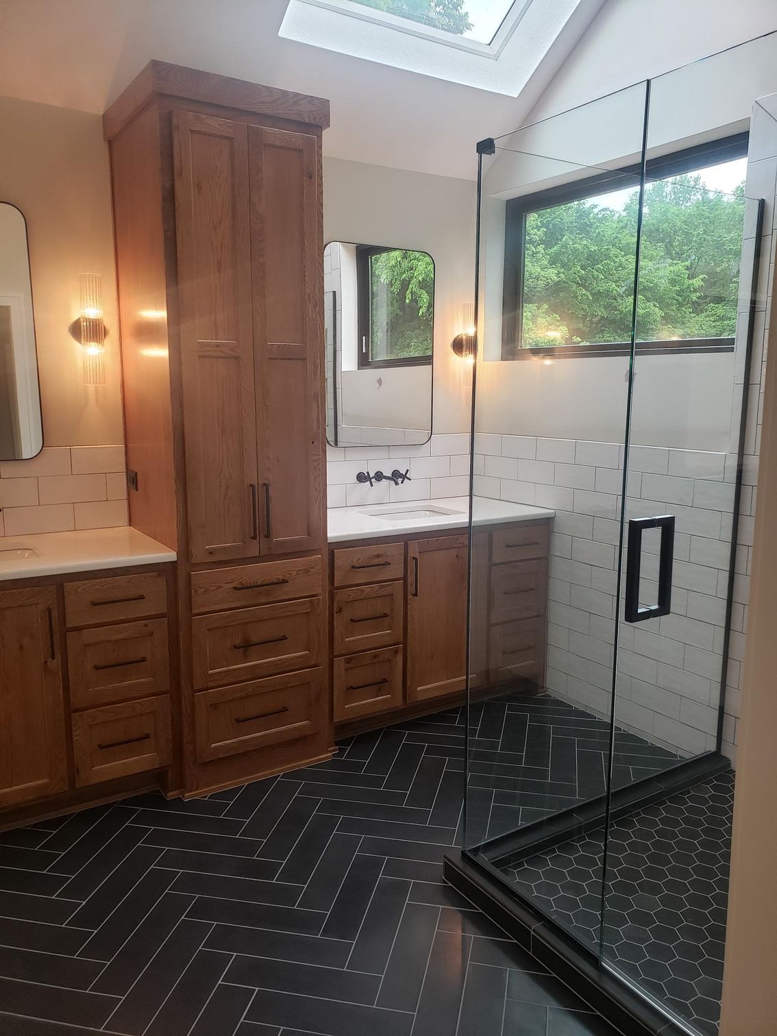 A bathroom with two sinks and a walk in shower.