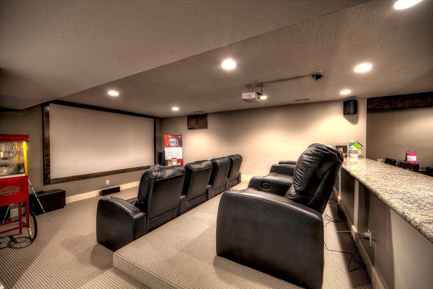 A home theater with a large screen and a popcorn machine.