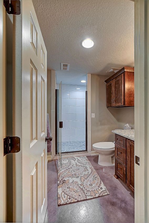 A bathroom with a toilet , sink , and walk in shower.