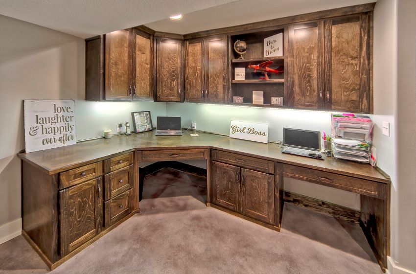 A home office with a corner desk and cabinets.