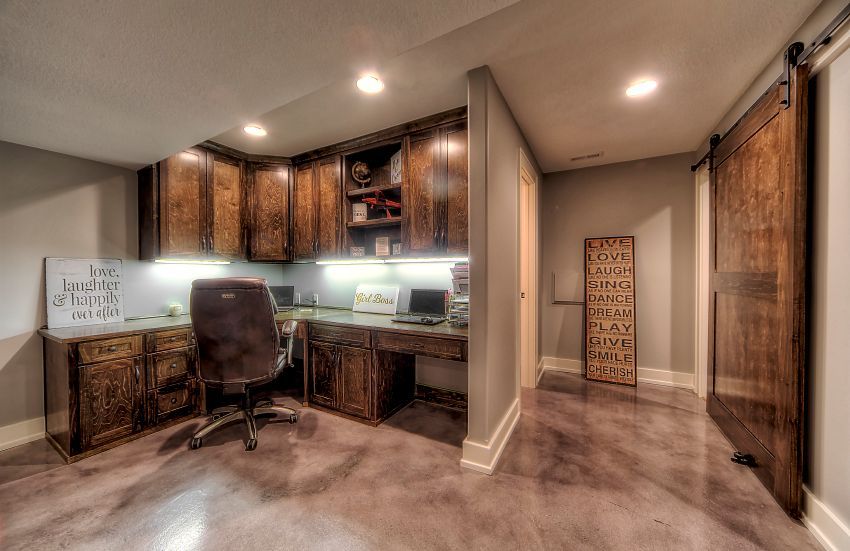 A home office with a desk and chair in a basement.