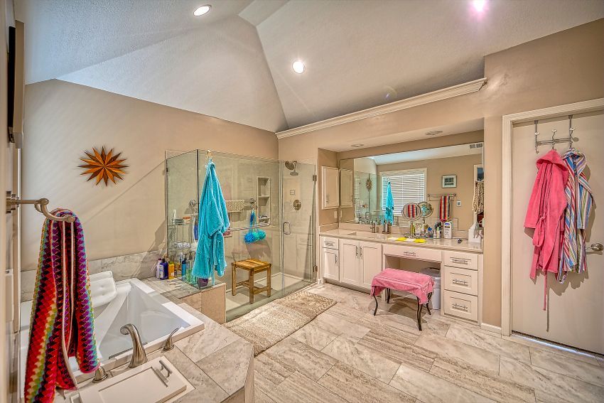 A bathroom with two sinks , a tub , and a walk in shower.