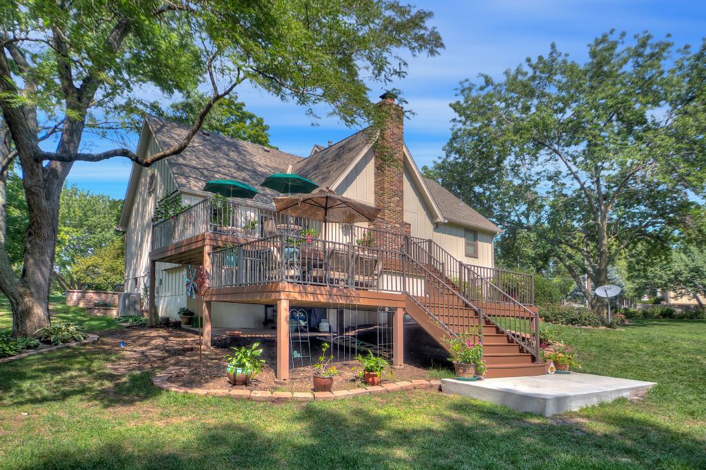 The back of a house with a large deck and stairs.