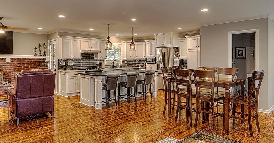 There is a large kitchen with a dining table and chairs in the middle of the room.