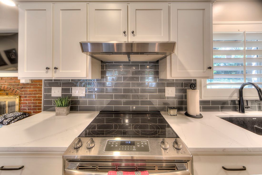 A kitchen with a stove top oven and a sink.