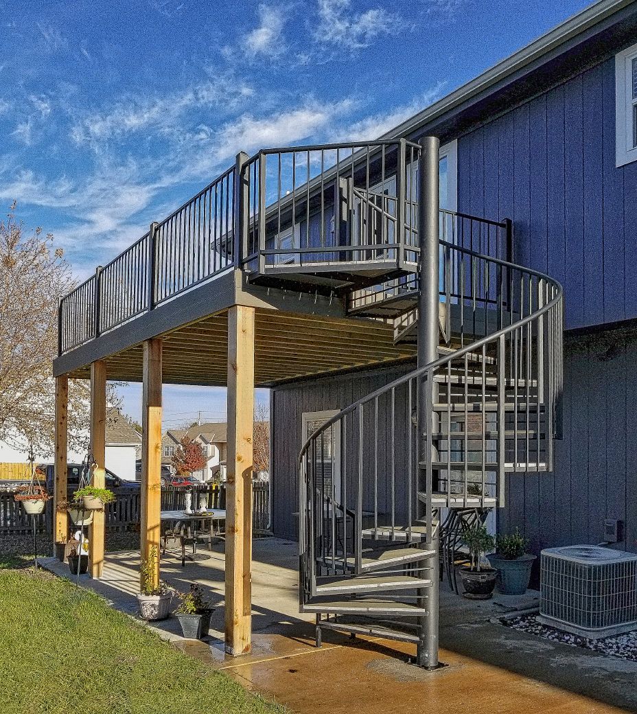 A blue house with a spiral staircase on the side of it