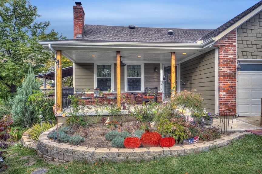 A house with a porch and a garden in front of it