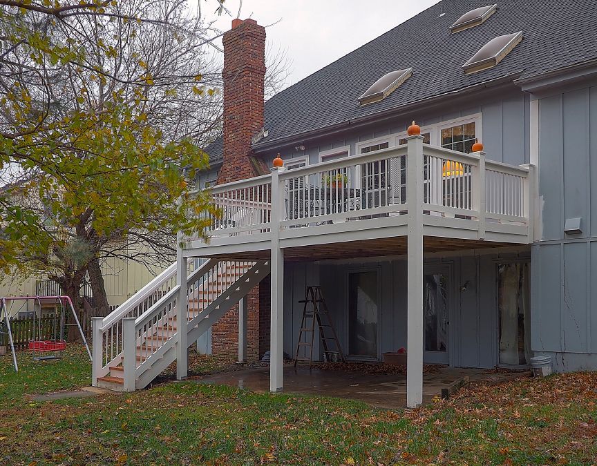 A blue house with a white deck and stairs