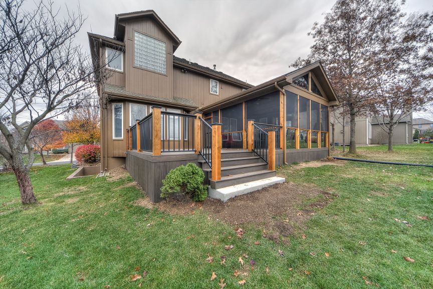 A large house with a screened in porch and stairs.