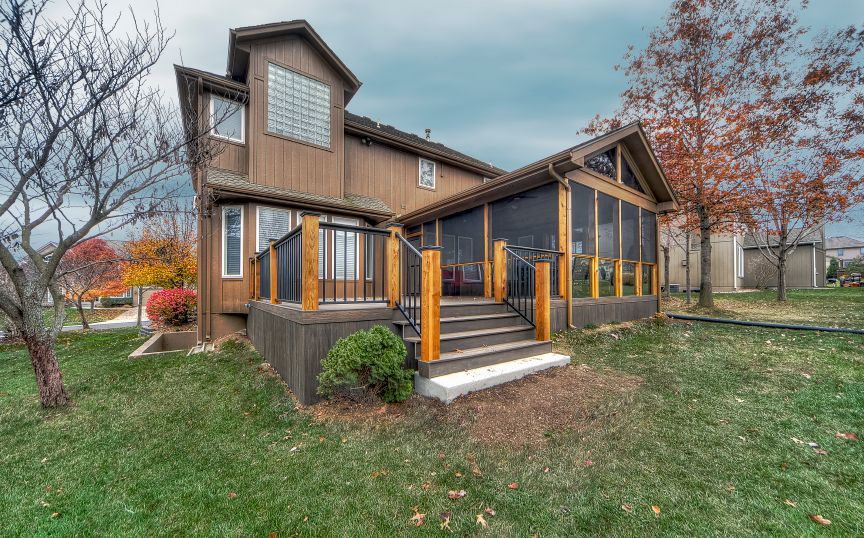 A large house with a screened in porch and stairs.