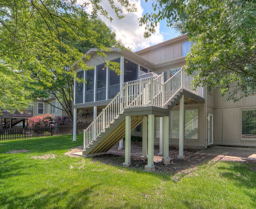 A large house with a large deck and stairs leading up to it.
