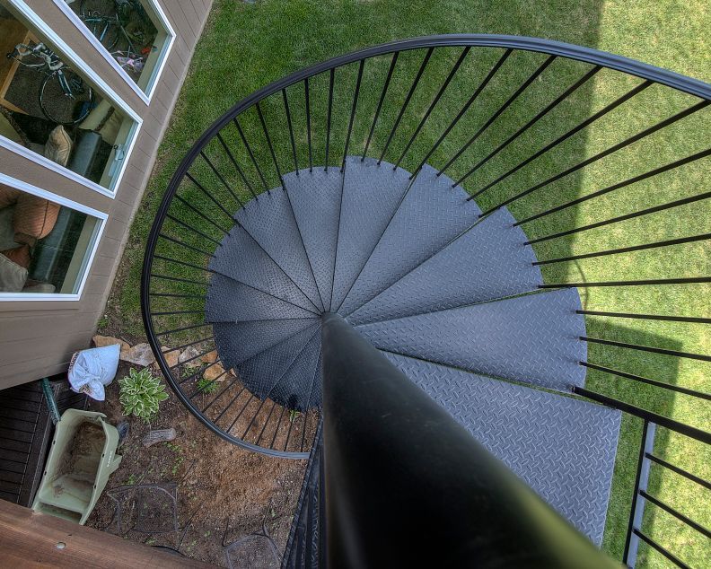 An aerial view of a spiral staircase in a backyard.