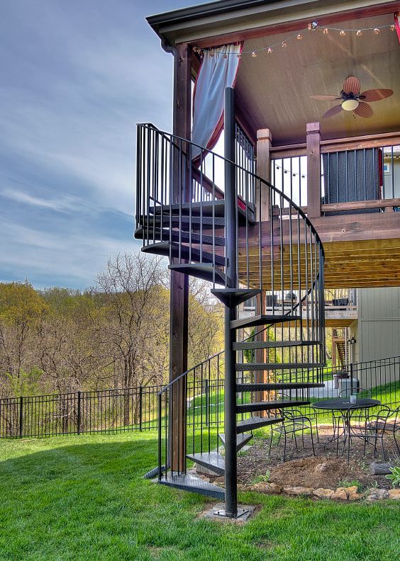 A house with a spiral staircase leading up to a deck