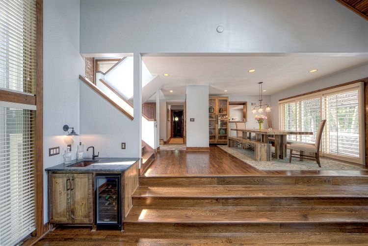 A kitchen with a sink , refrigerator , and stairs leading to a dining room.