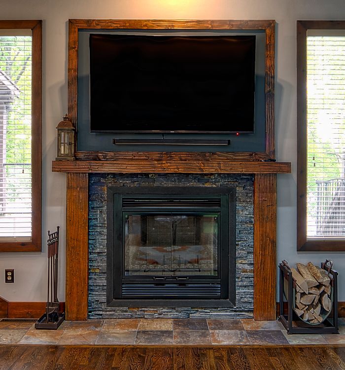 A living room with a fireplace and a flat screen tv above it.