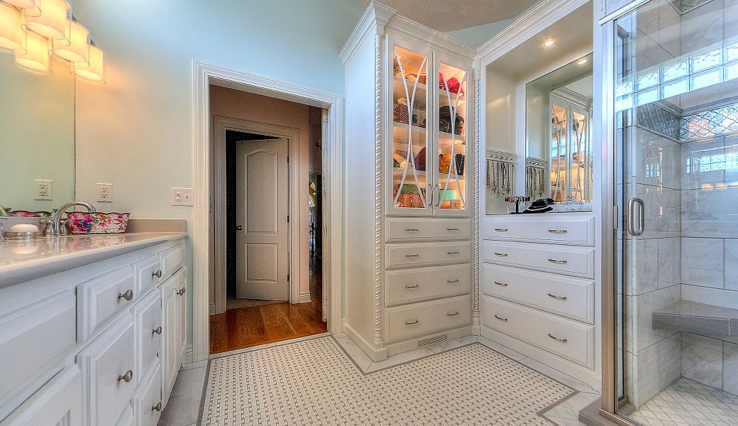 A bathroom with a walk in closet and a shower.