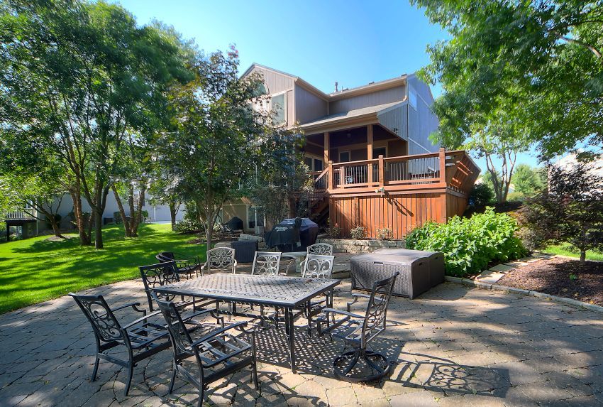 A patio with a table and chairs in front of a house.