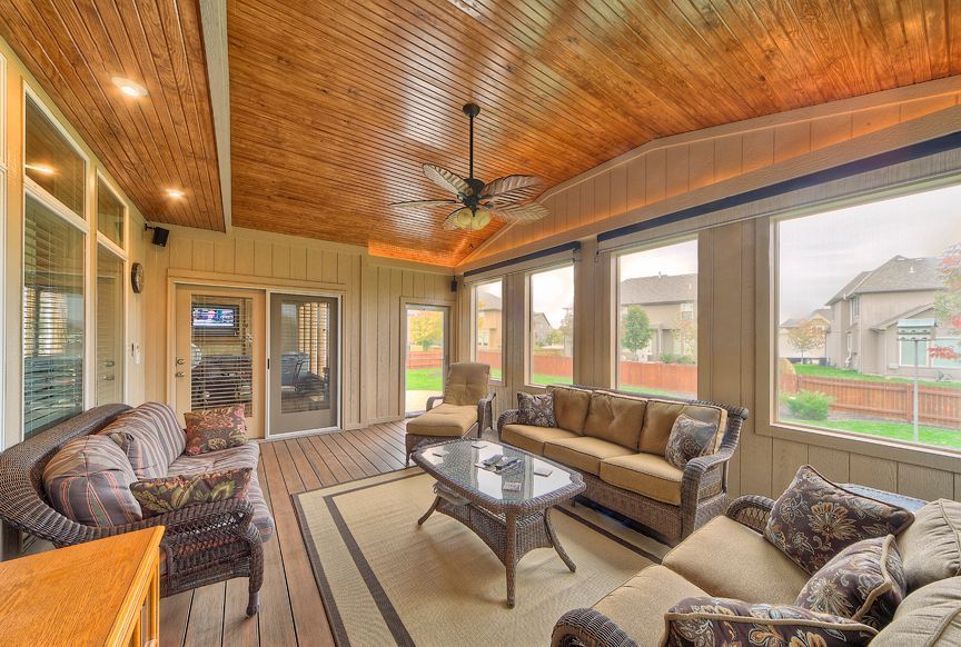 A living room with a lot of furniture and a ceiling fan.