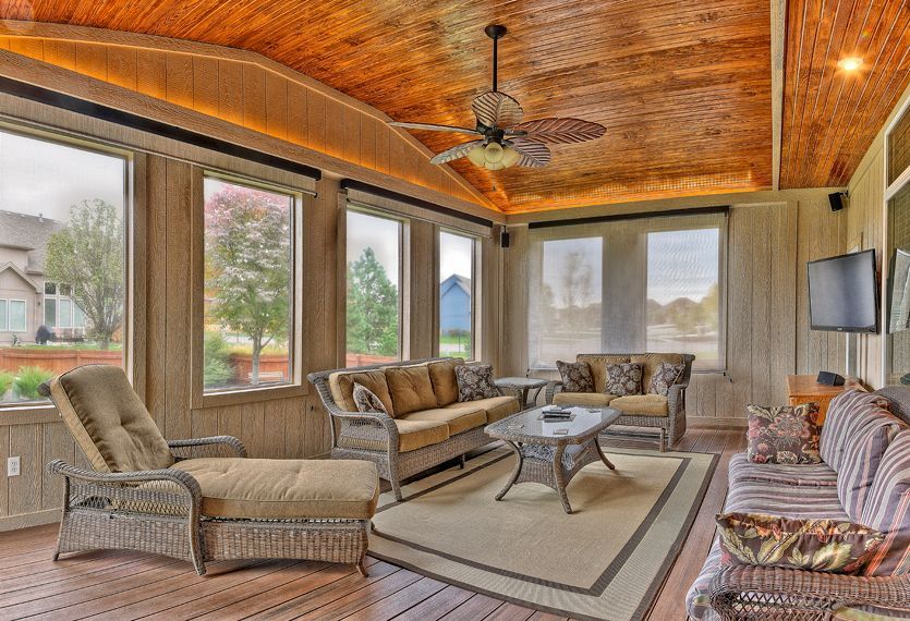 A living room with a couch , chairs , and a ceiling fan.