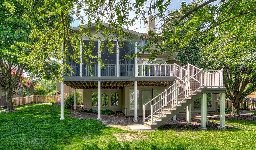 The back of a house with a large deck and stairs.