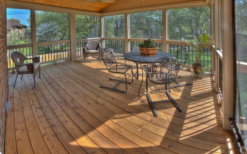 A screened in porch with a table and chairs