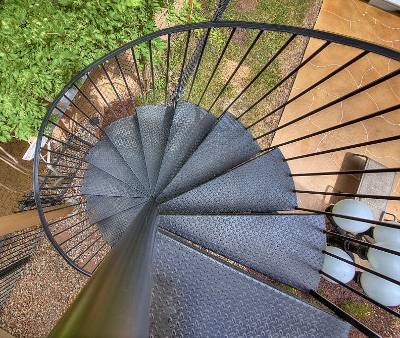 An aerial view of a spiral staircase with a metal railing