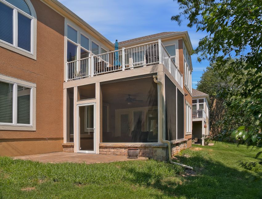 A house with a screened in porch and a large deck