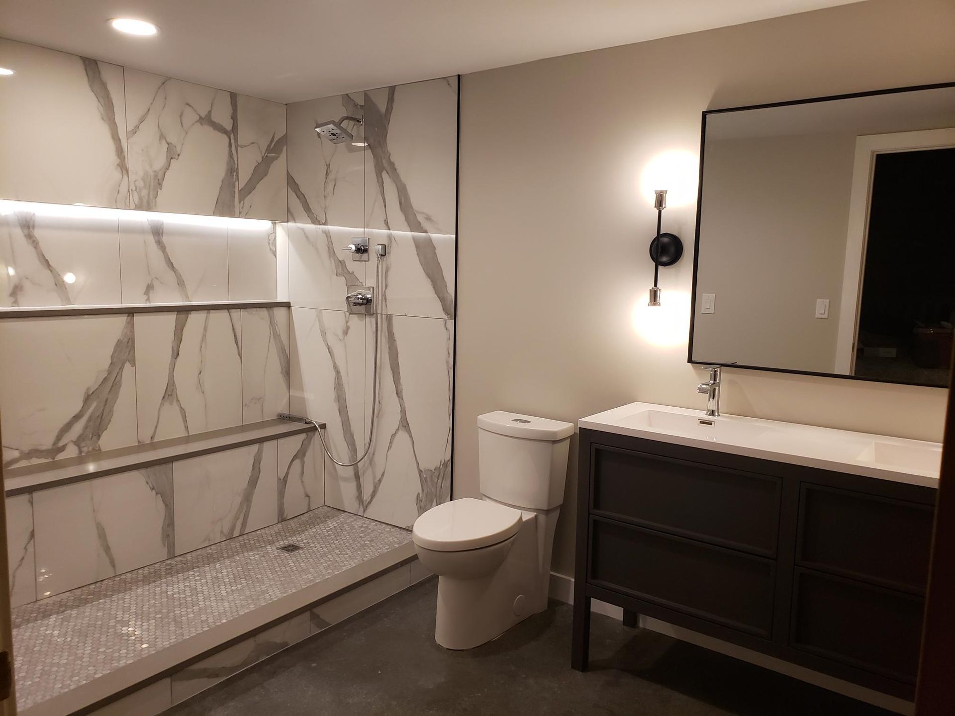 A bathroom with a toilet , sink and shower.