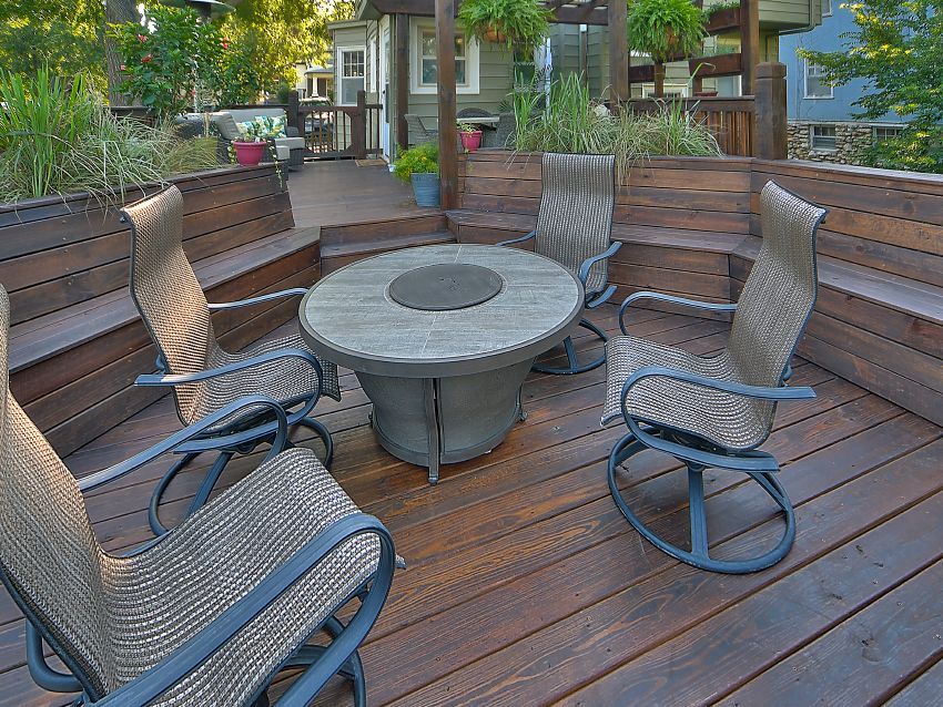 A wooden deck with a table and chairs on it.