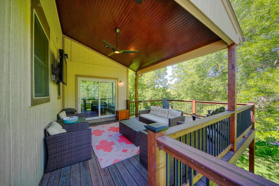 A large deck with furniture and a ceiling fan.