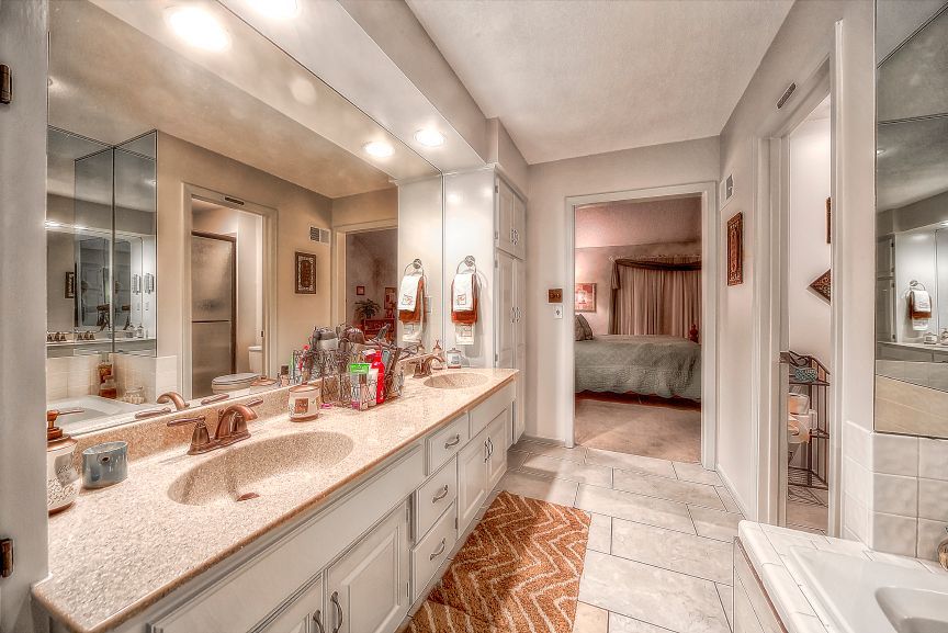 A bathroom with two sinks and a large mirror