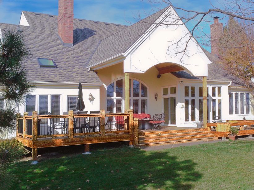 A large white house with a wooden deck in front of it