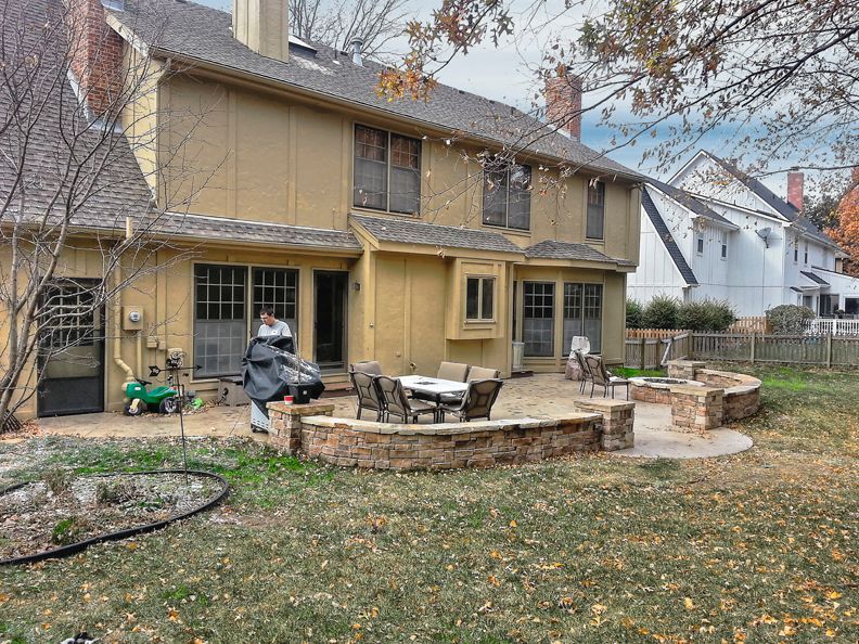 The backyard of a house with a patio and a table and chairs.