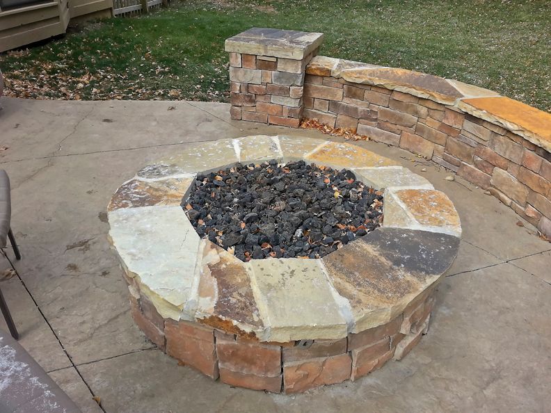 A fire pit made of rocks and bricks on a patio
