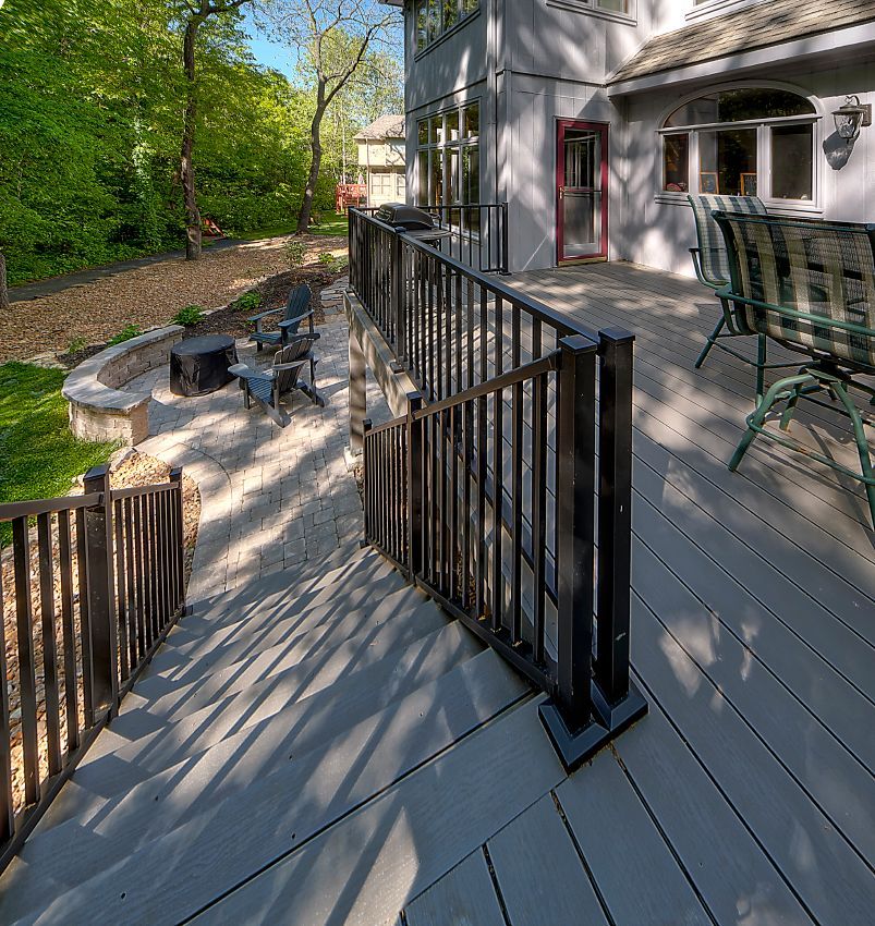 A large deck with a black railing and a fire pit