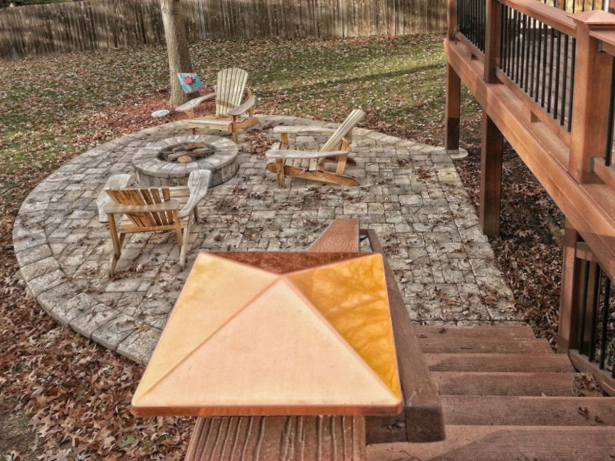 A patio with a fire pit and chairs on it
