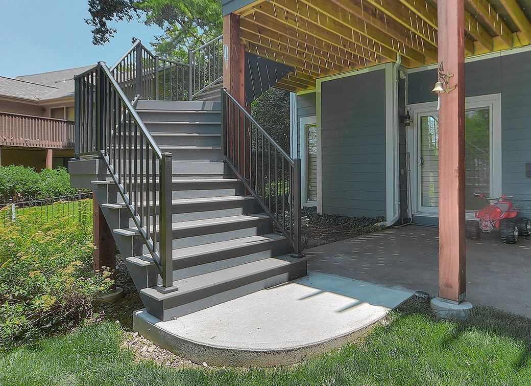A deck with stairs leading up to it and a pergola.