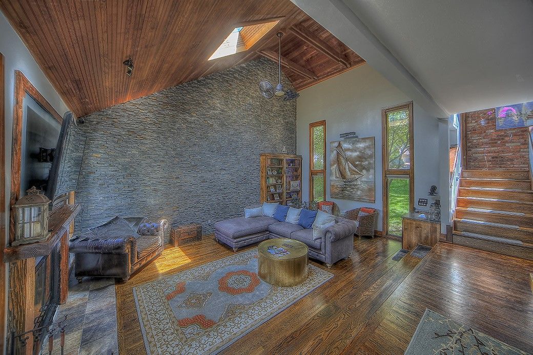 A living room with a couch and stairs in a house.