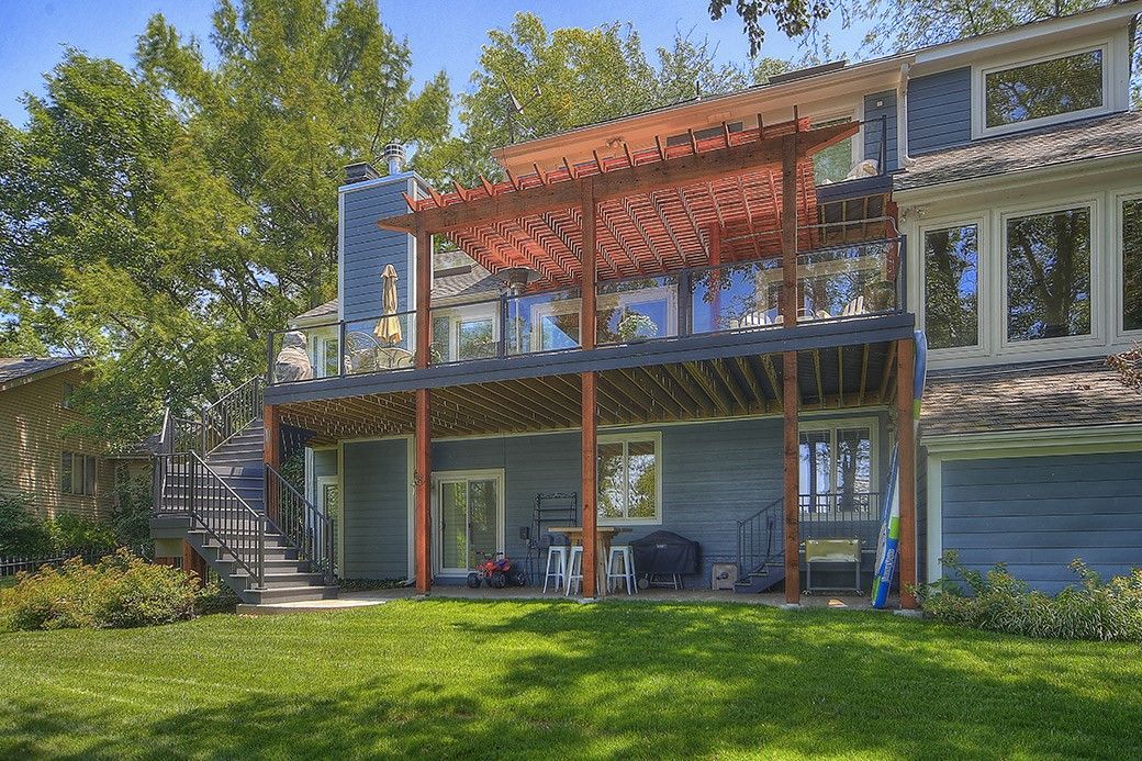 The back of a house with a pergola on top of it.