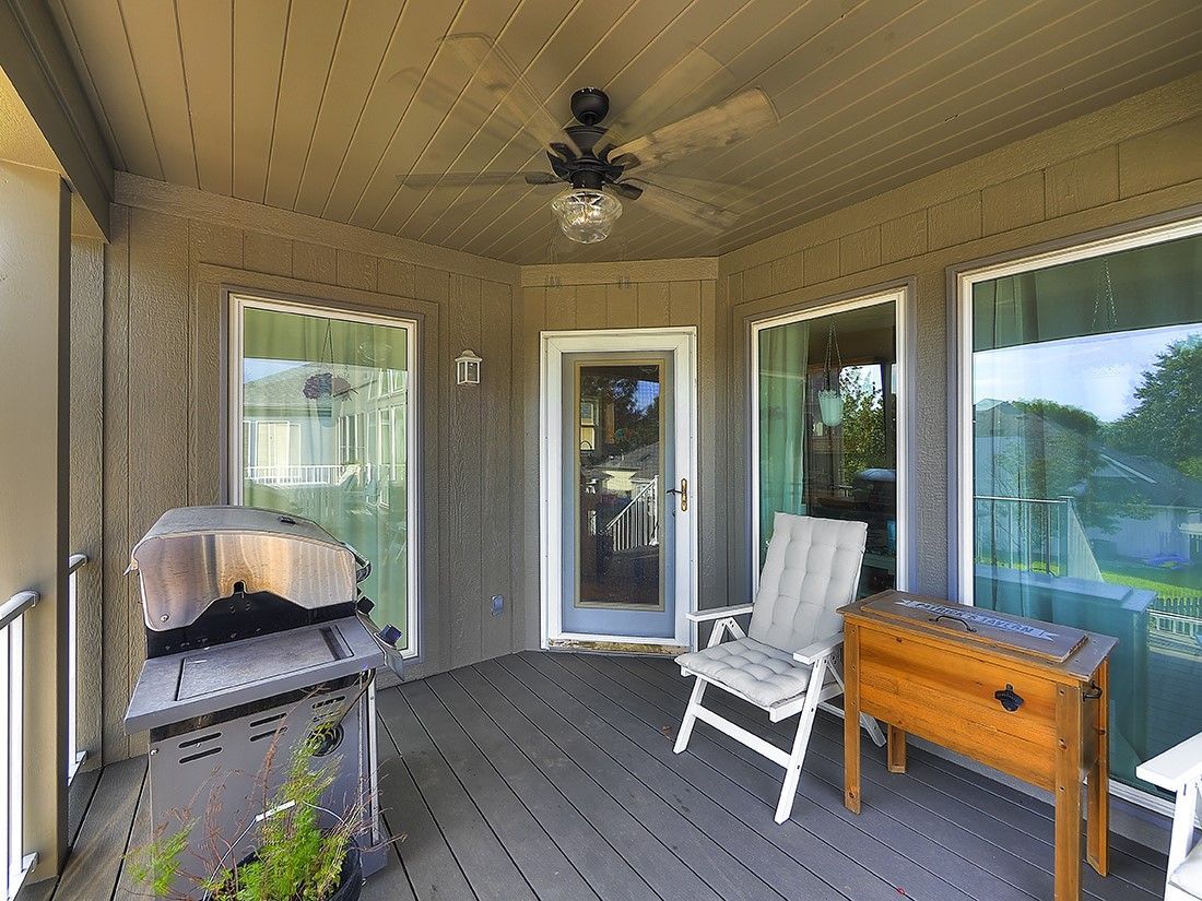 There is a ceiling fan on the porch of a house.