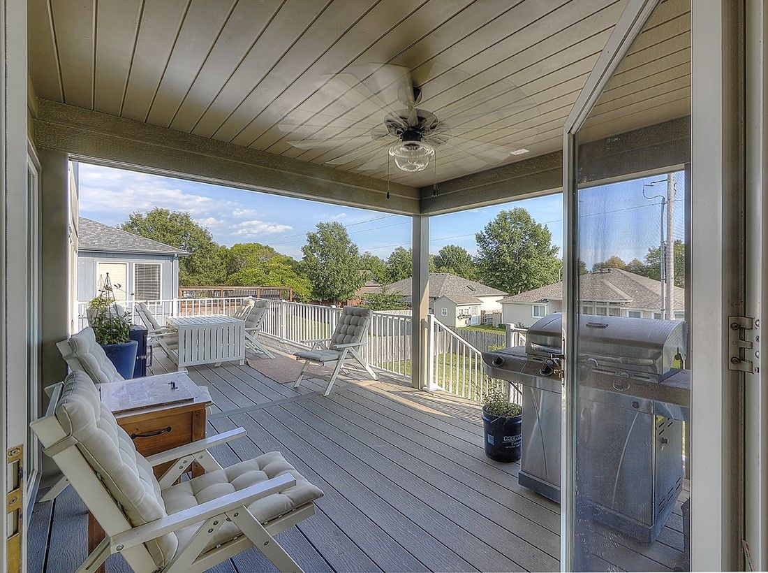 A porch with a chair and a ceiling fan