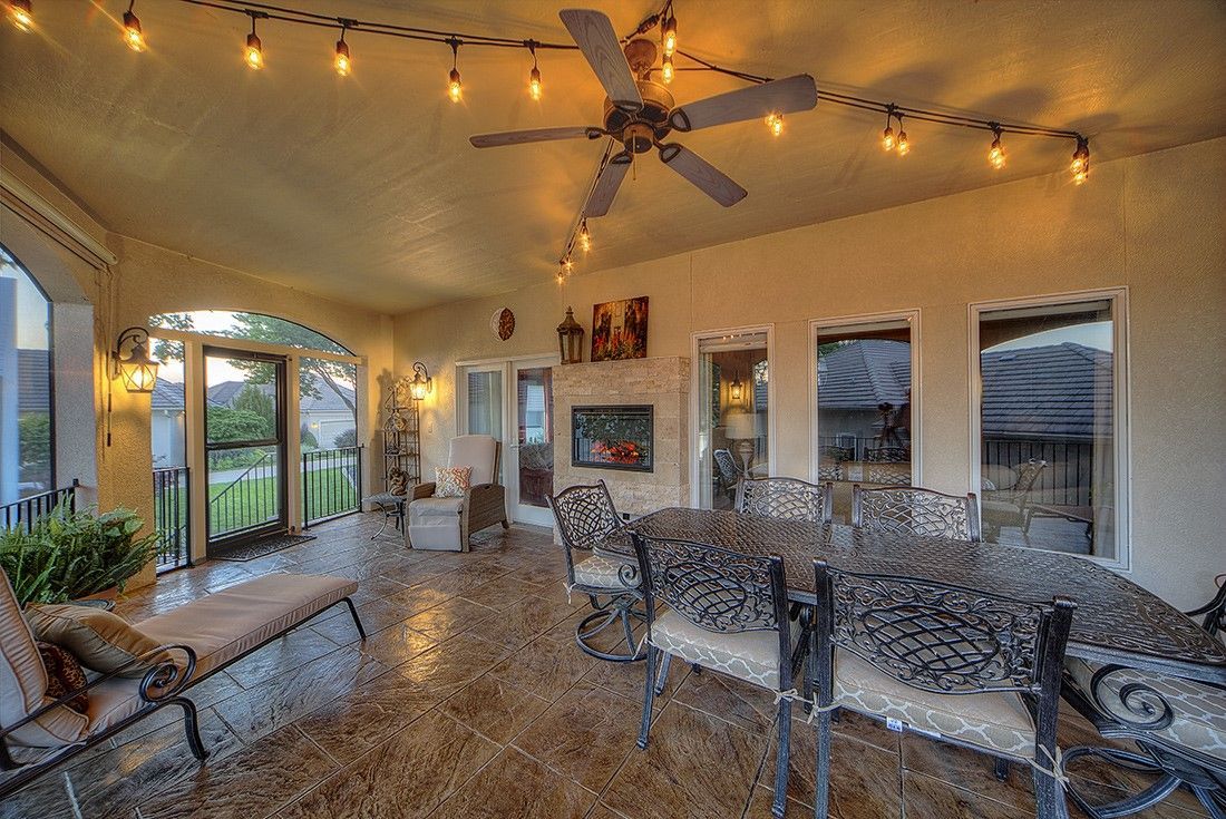 A large room with a table and chairs and a ceiling fan.