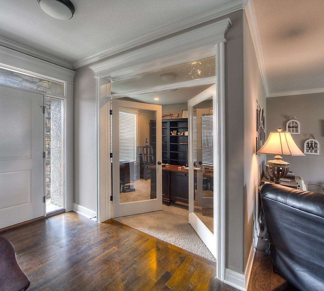 A living room with a black chair and a lamp