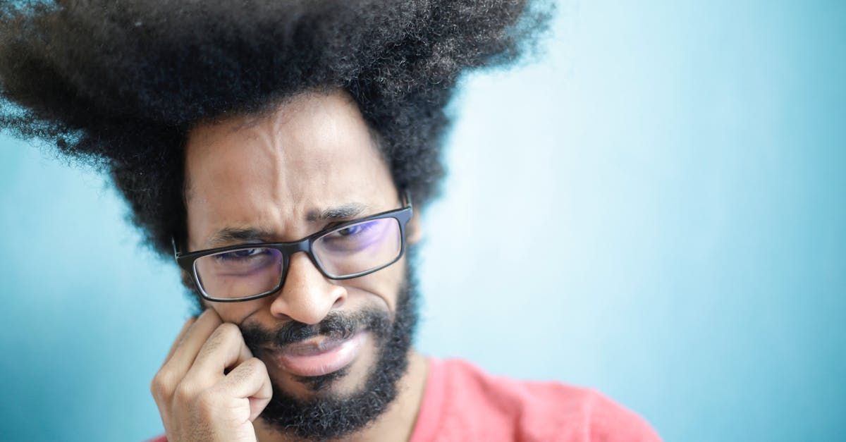 A man with glasses and a beard is making a funny face.