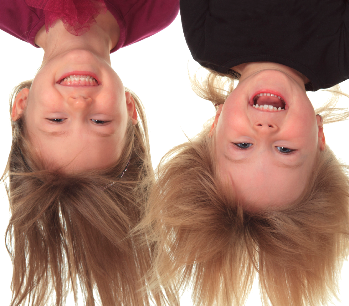 Two smiling children hanging upside down