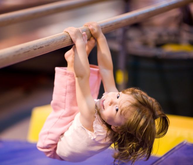Young girl, in leotard, jumping and smiling