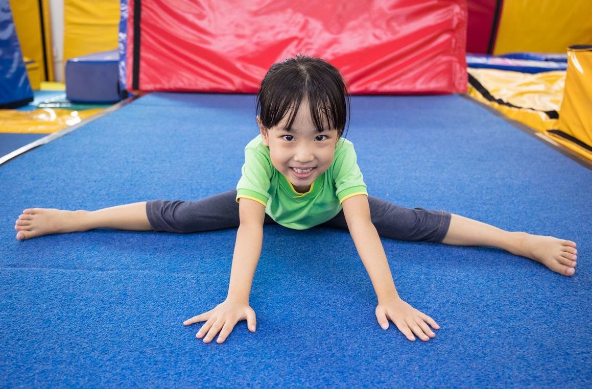 Young girl, in leotard, jumping and smiling