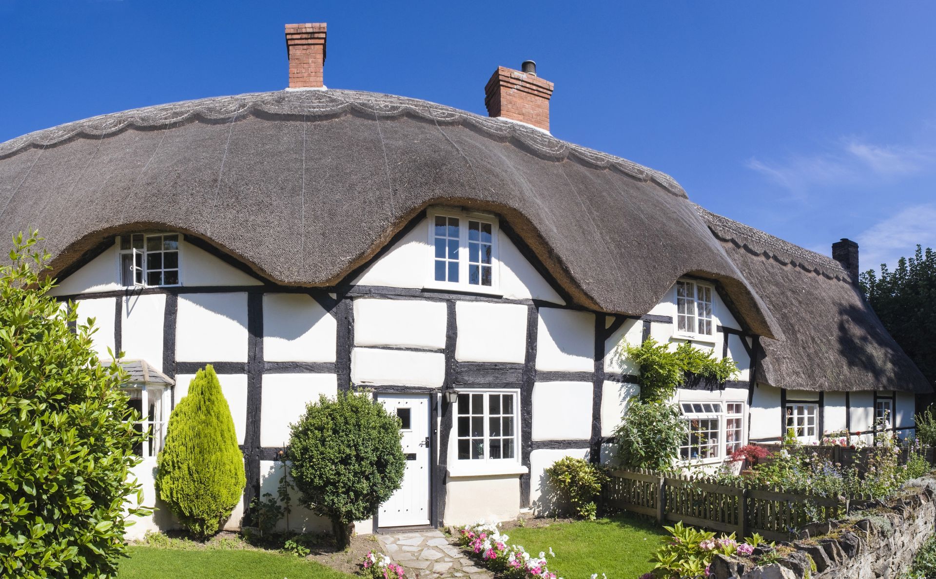 A black and white house with a thatched roof